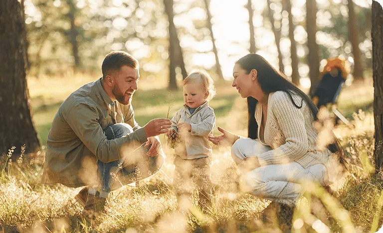 Familie mit Mutter, Vater und Kind im Wald.